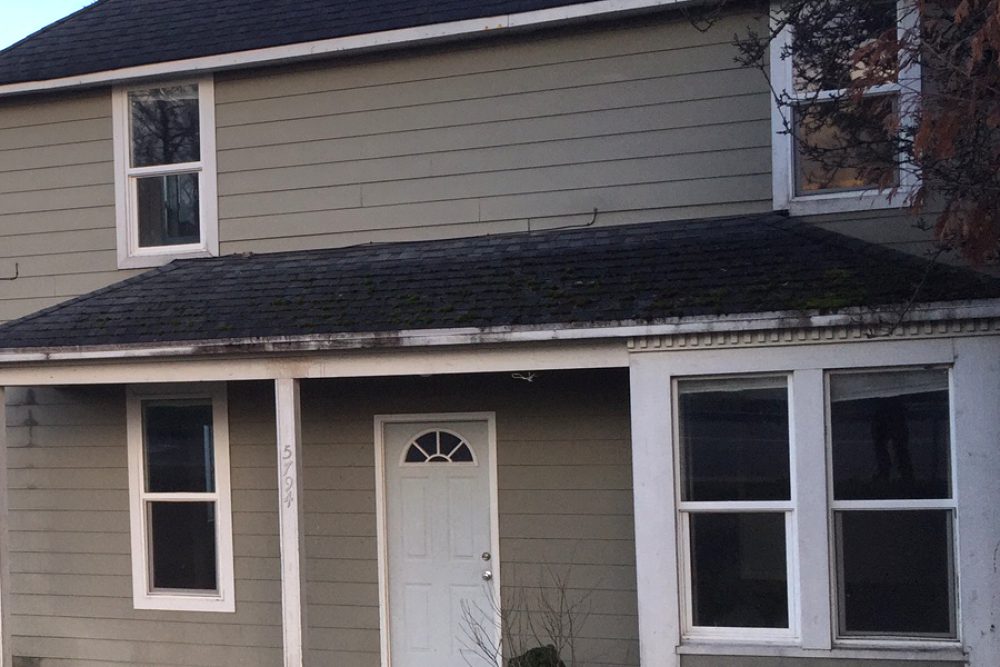 Tan two-story rental house with a covered front entry