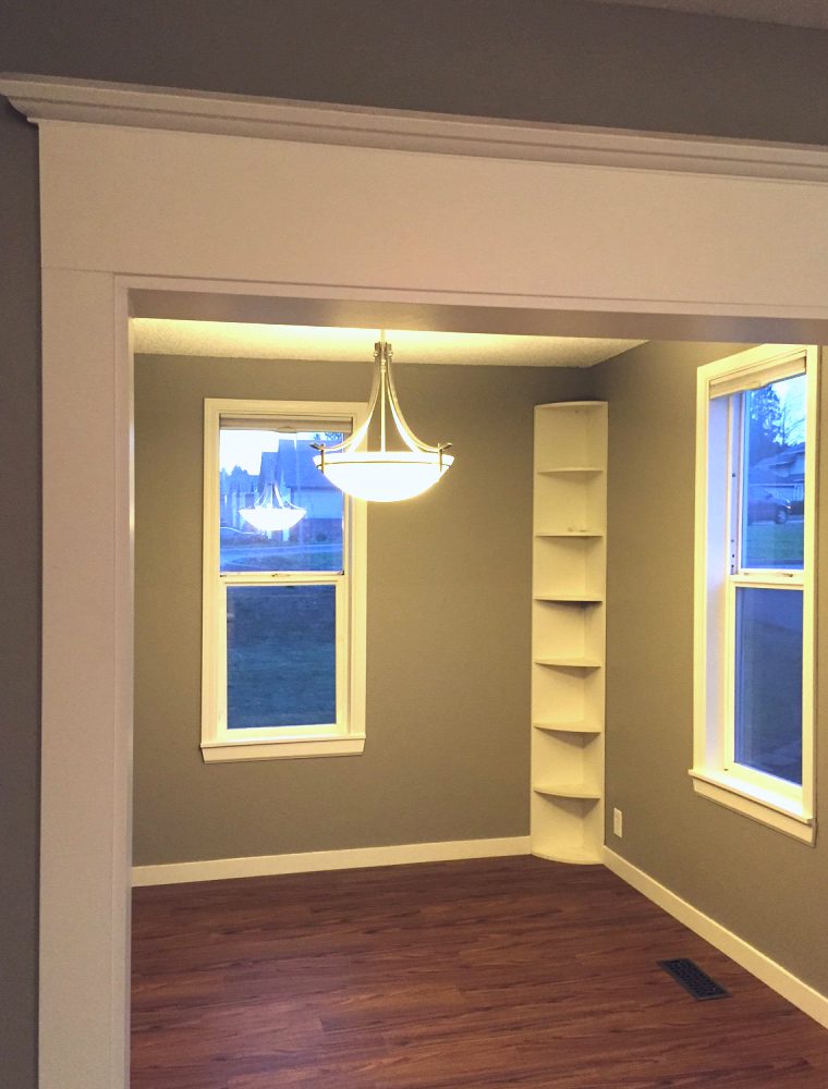 Dining nook with a pendant light and built-in corner shelves